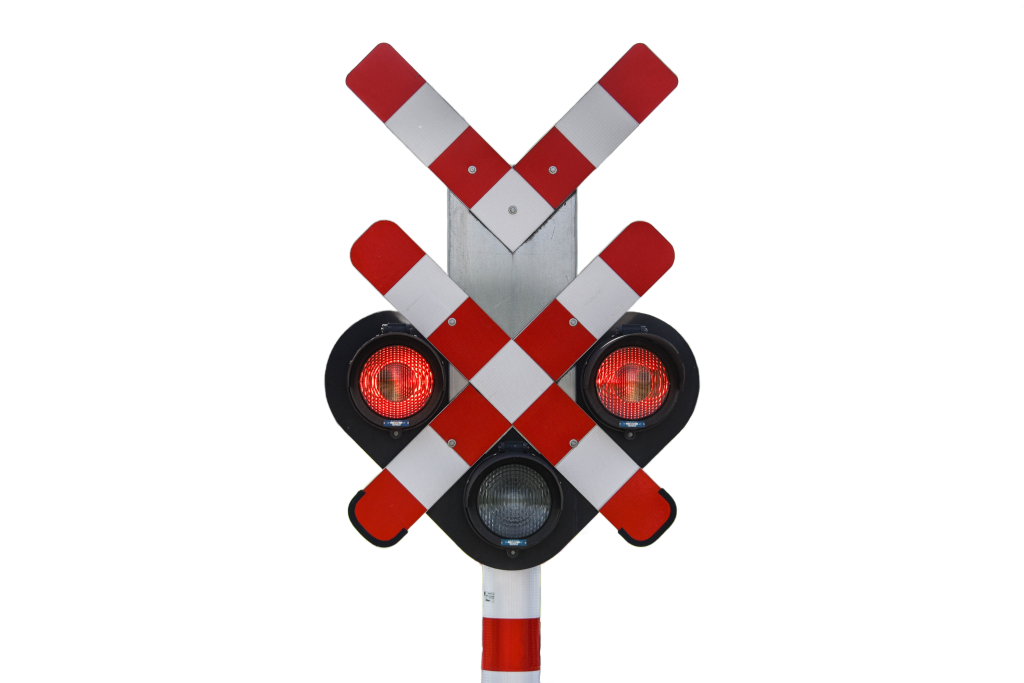 Andreaskreuz mit rot leuchtender Warnlampe an einem Bahnübergang in Deutschland