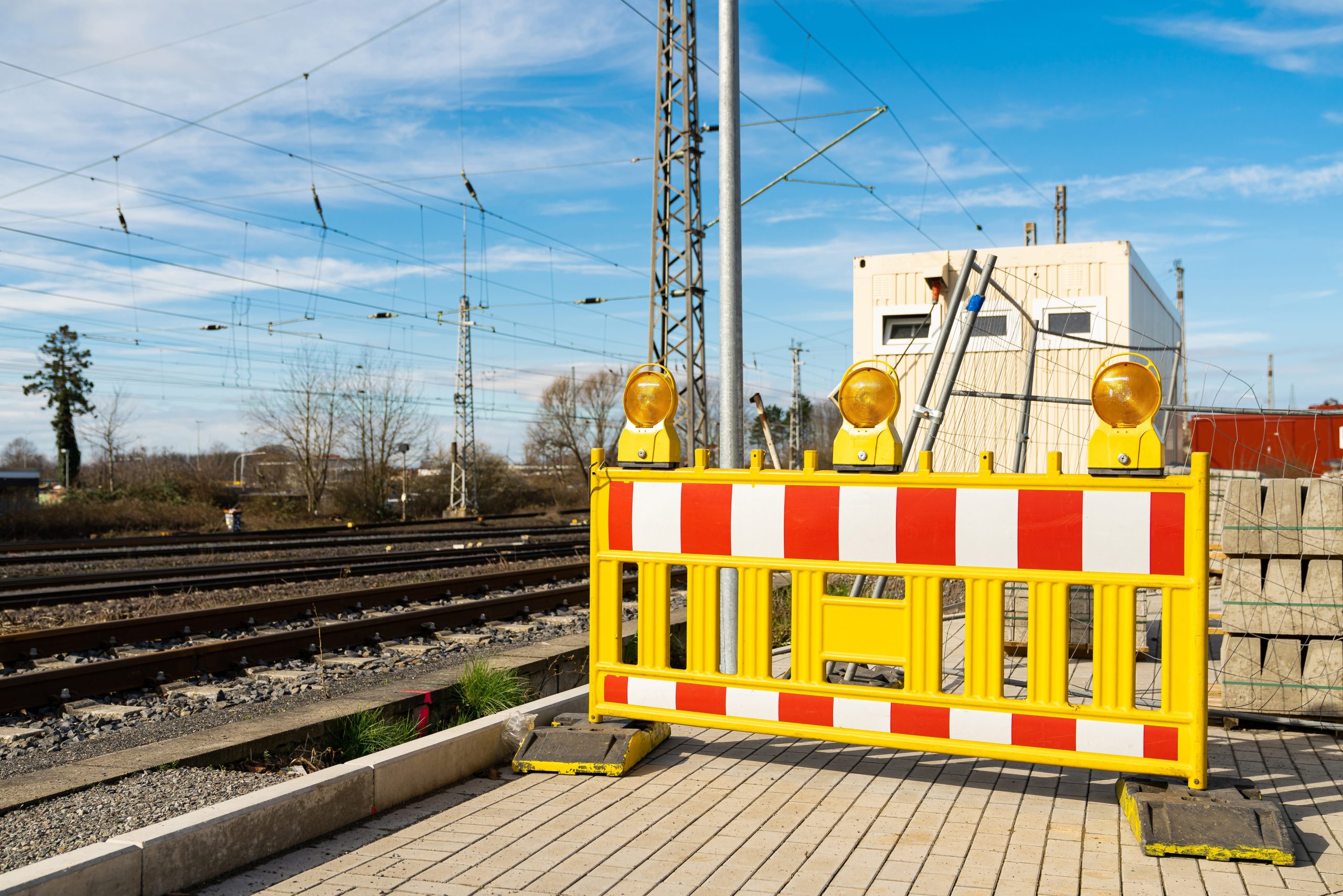 Mobile Absperrung an einem Gleisbauarbeitsplatz mit Warnleuchten im Bahnbereich.